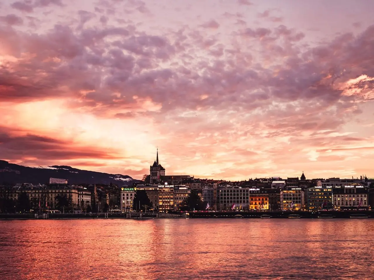 Geneva waterfront under a pink sunset sky