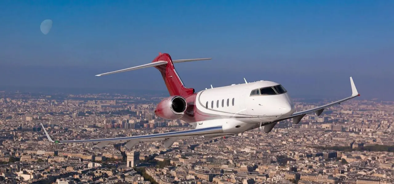 Private jet flying over Paris with the Arc de Triomphe below