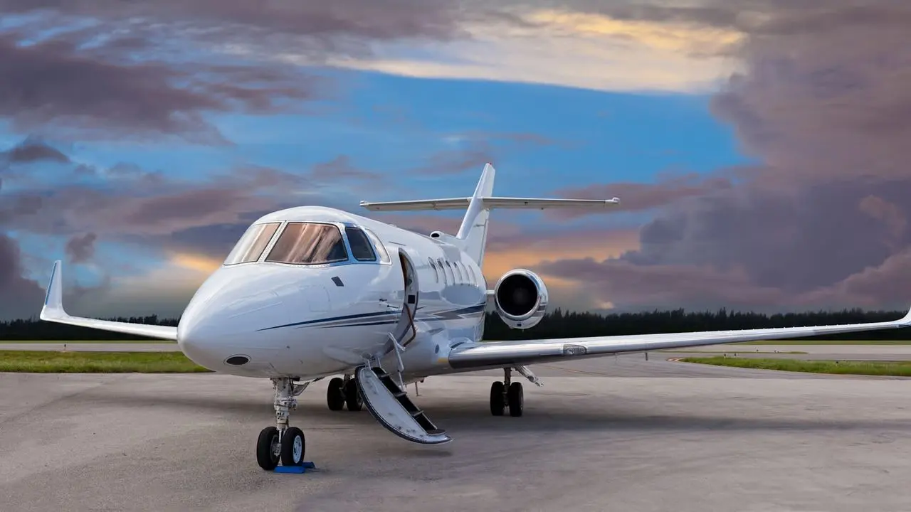 Private jet with its airstair lowered on the apron at dusk