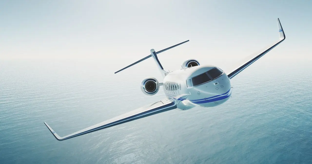 Private jet in flight over the sea