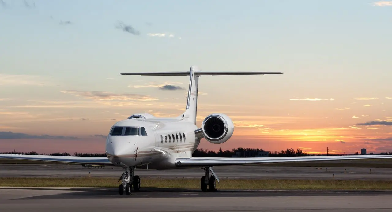 Private jet standing on the runway at sunset