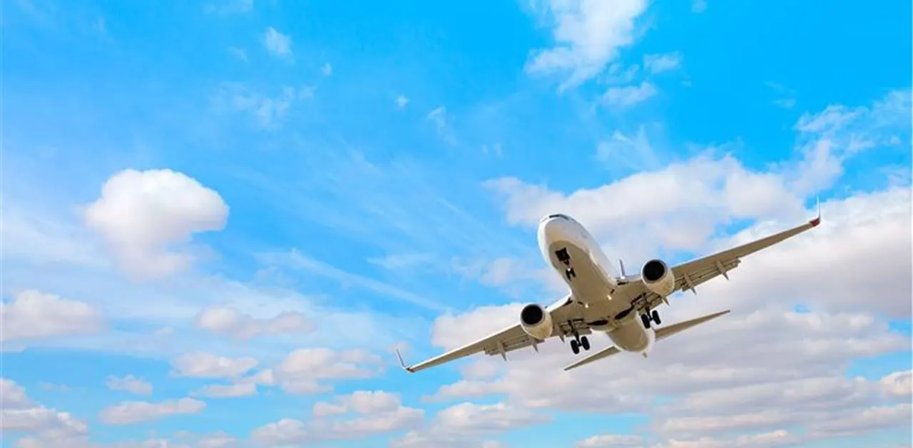 Private jet taking off against a bright blue sky