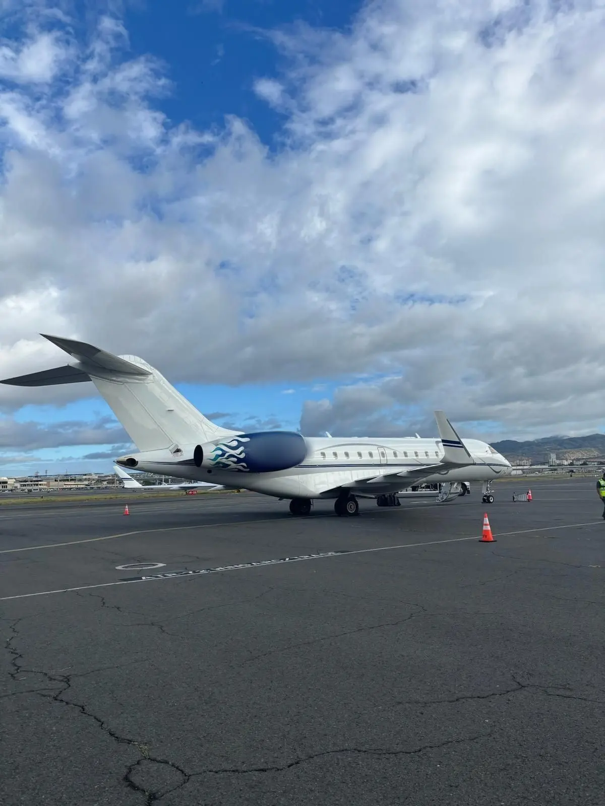 Private jet on the apron under a blue sky with scattered cloud