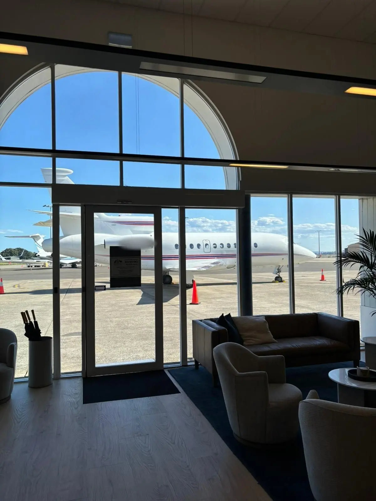 Private jet terminal lounge with an arched window looking out to the apron