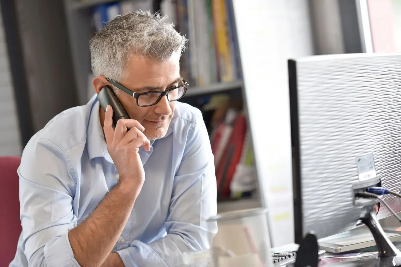 A man on the telephone at a desk