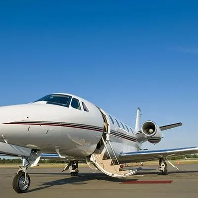 Private jet parked on the tarmac with its airstair door open