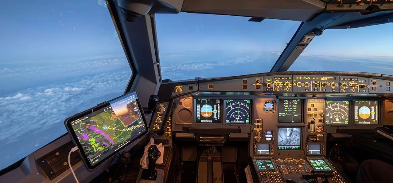 Modern flight deck with digital display screens above the clouds