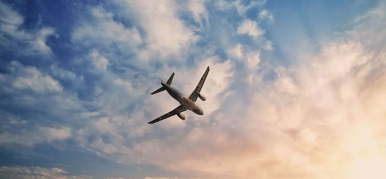 Private jet flying through a sky filled with soft clouds